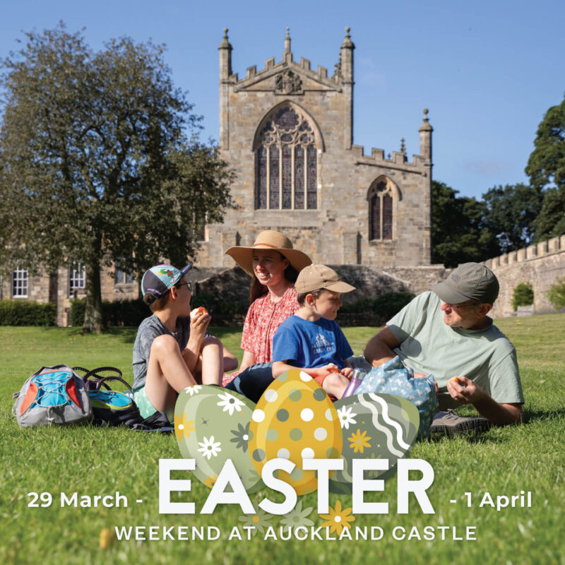 A mum, dad, son and daughter sit on the green grass in front of Auckland Castle. The sky is blue and the sun beats down on the family, who smile as they enjoy a picnic. Over this image, there are three graphic Easter eggs in yellow and green patterns. Above these, white text says Easter Weekend at Auckland Castle.