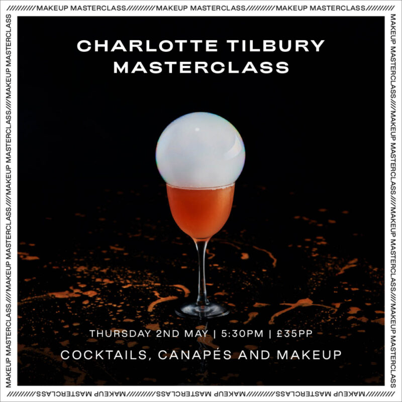An orange coloured cocktail is topped with a large smoke filled bubble in a long stemmed glass. White words sit above the glass, which read: Charlotte Tilbury Masterclass.