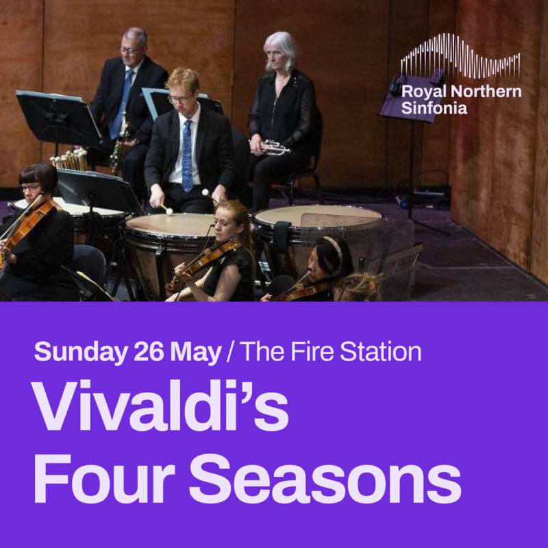 Three members of an orchestra's percussion section stand in front of music stands. A man bangs a drum with two sticks, looking forward intently at an unseen conductor. Below this image is some white text on a purple background. It says: Vivaldi's Four Seasons, The Fire Station.