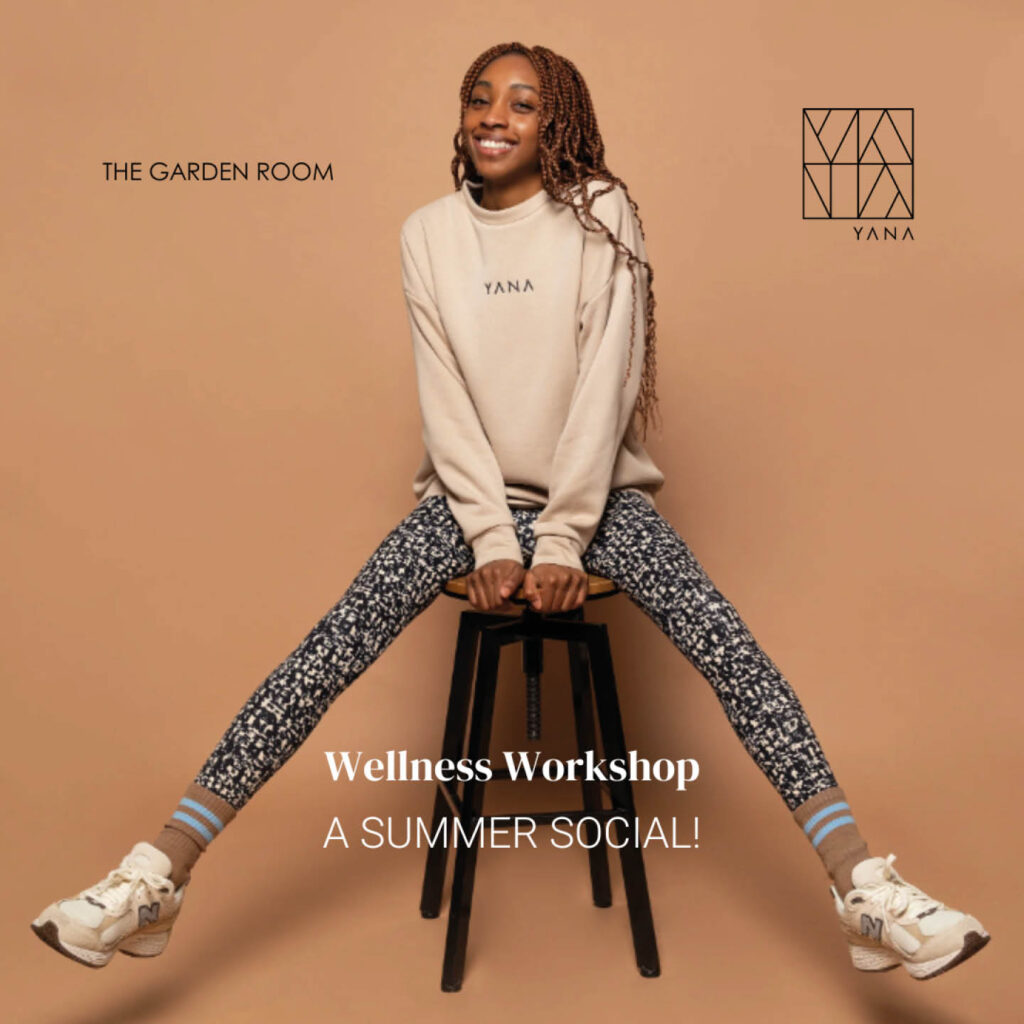 A young woman sits on a stool against a beige background. She wears black and white printed leggings and a beige YANA sweatshirt. She grins at the camera. Below her, white text says: Wellness Workshop, A Summer Social.