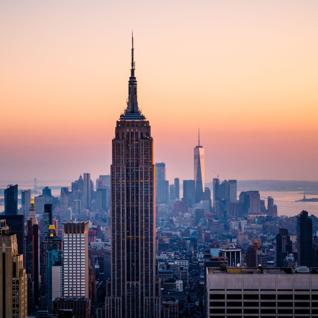 The New York skyline is set against a sunset with the empire state building in full view