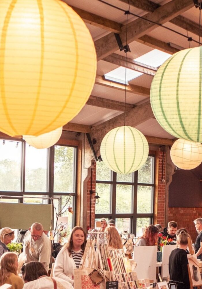 In an beautiful space, shoppers browse different booths of handmade and curated items