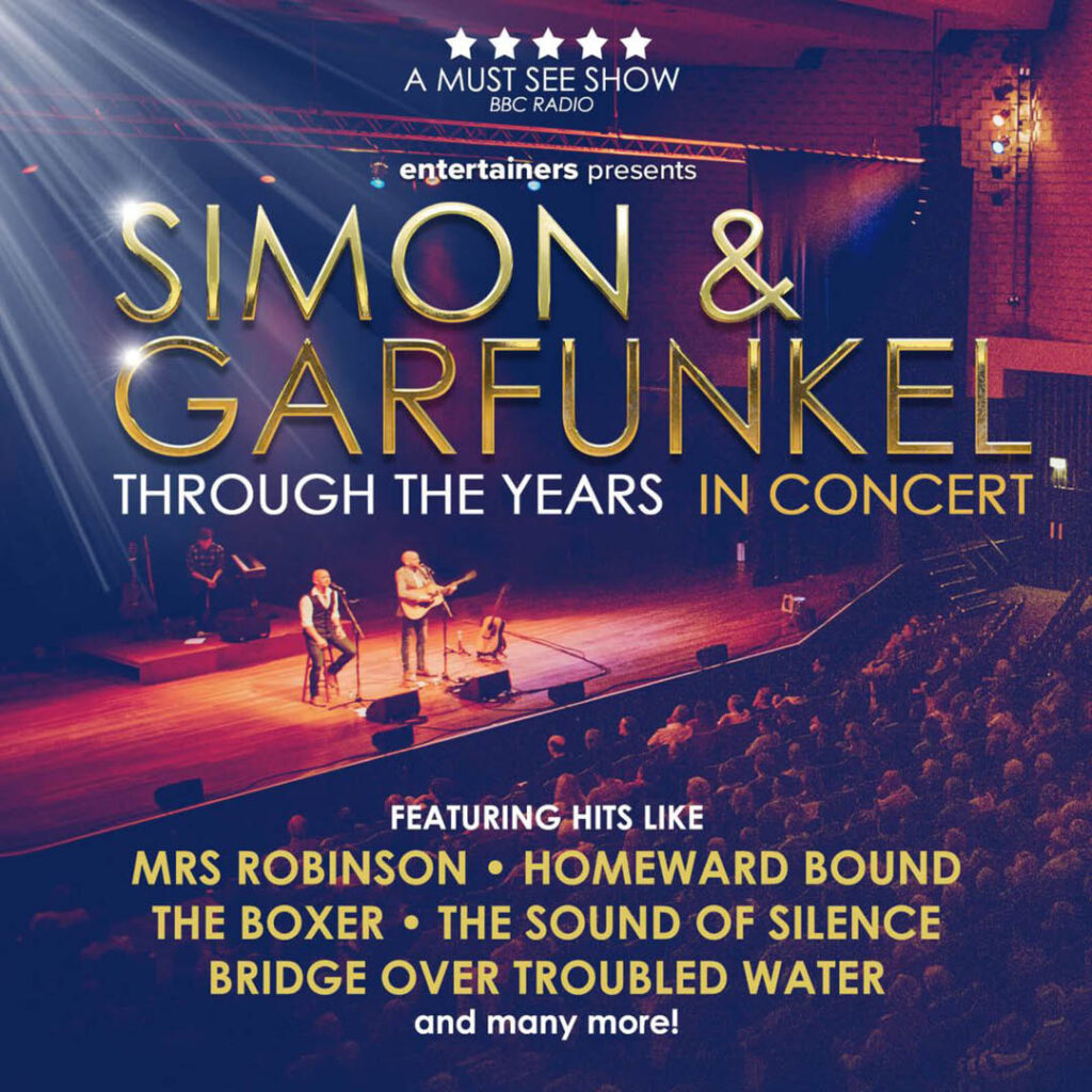 A concert hall of seated people watch the spotlit stage as two men play guitar and sing. They are the Simon and Garfunkel tribute act for the Through the Years show.