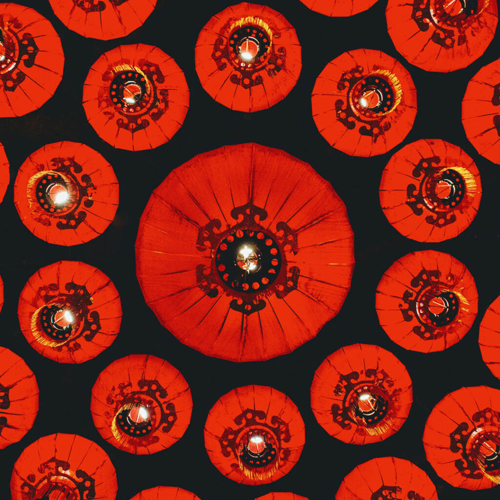 View from below of beautiful red Chinese lanterns lit from within.