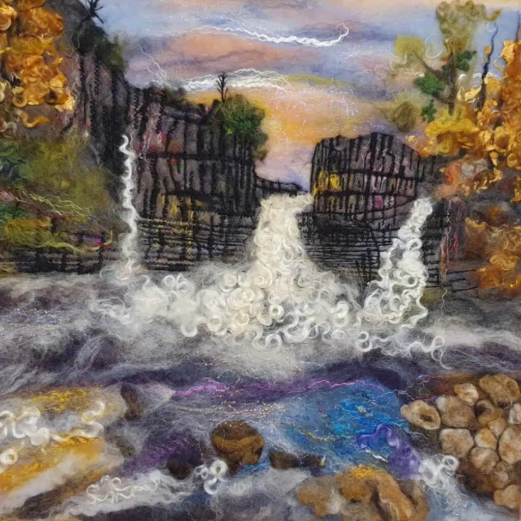 An embroidered landscape of a waterfall crashing between two cliffs surrounded by autumnal trees.