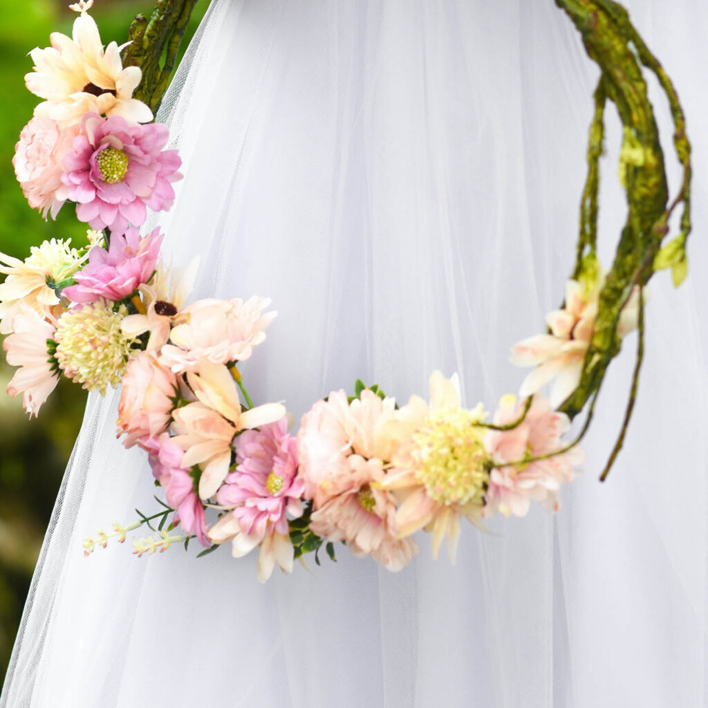A flower crown made from natural willow and pink, yellow and white flowers.